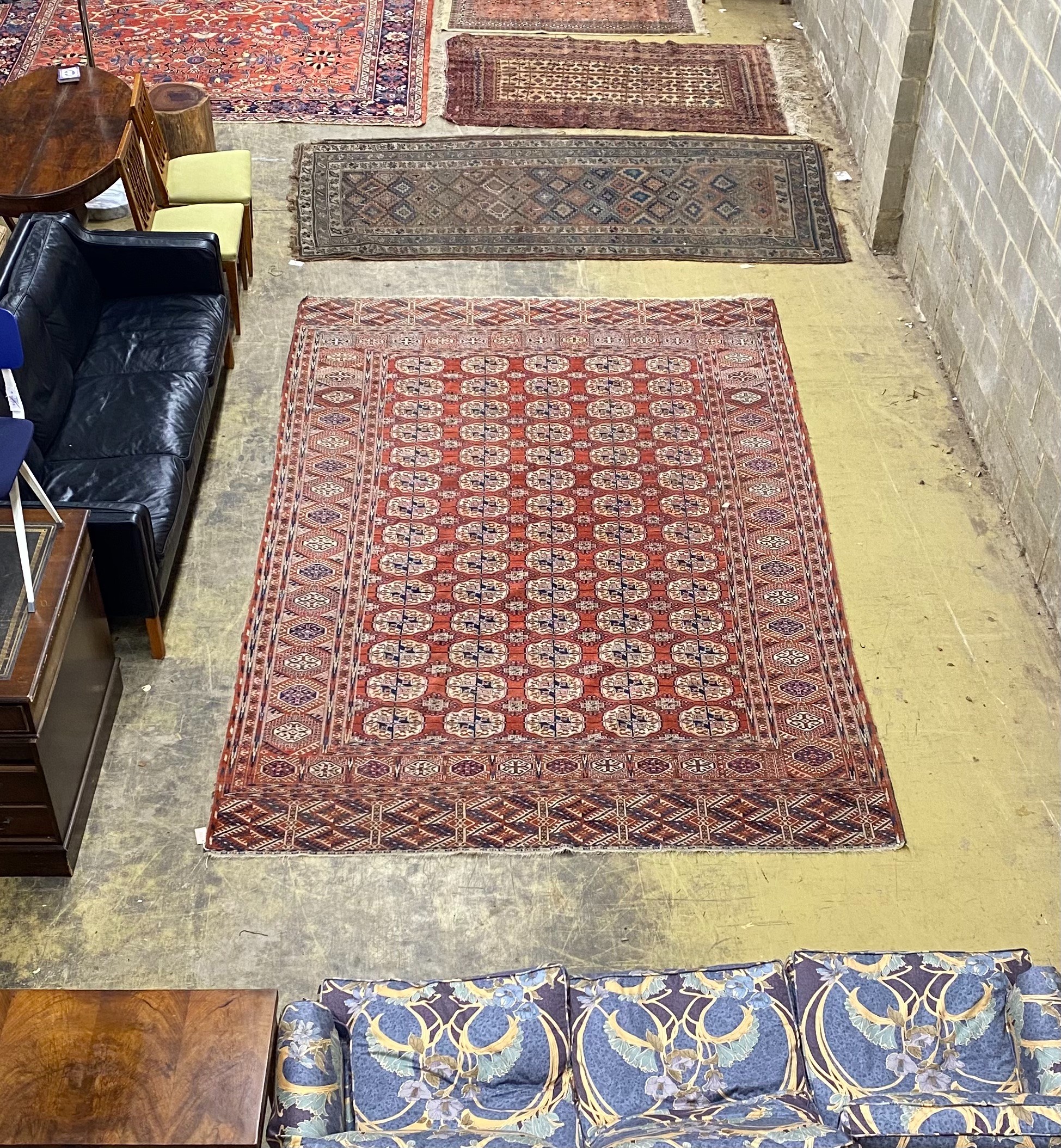 A Bokhara brick red ground carpet, 350 x 230cm